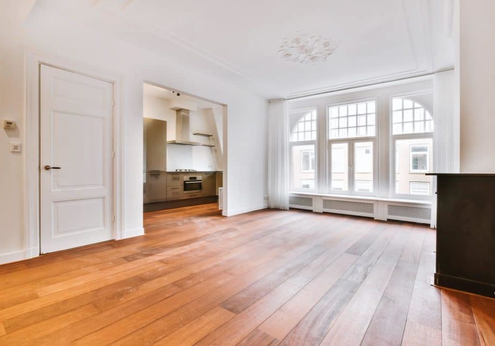 A bright room with an arch to the kitchen